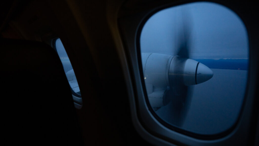 Aleutian Saab 2000 turboprop is seen from the aircraft window at night during take off.