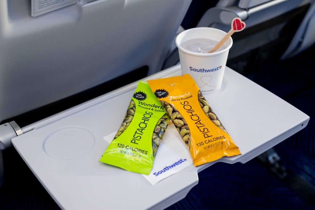 Two snacks and a drink sit on the aircraft table.