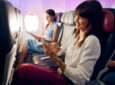 Virgin Australia cabin shows two people seated with the middle seat empty for more space.