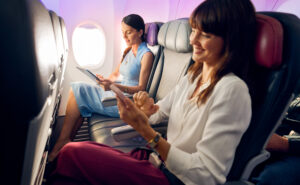 Virgin Australia cabin shows two people seated with the middle seat empty for more space.