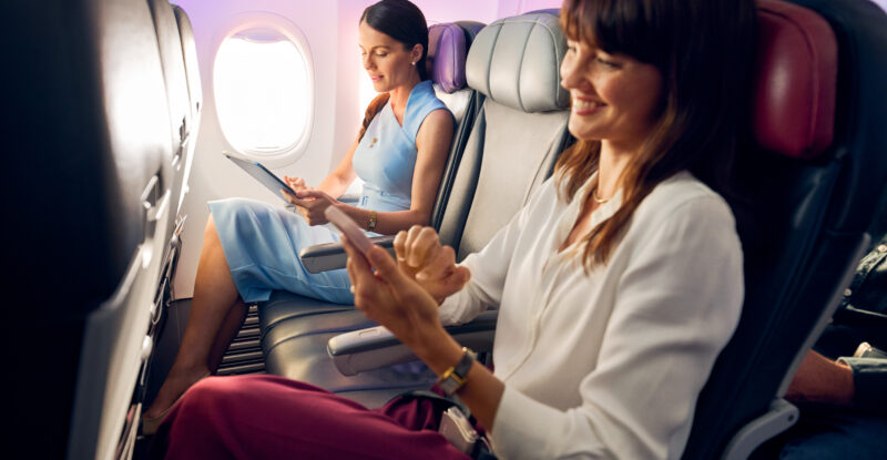 Virgin Australia cabin shows two people seated with the middle seat empty for more space.