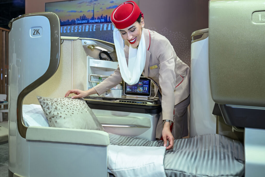 Emirates' new hooded mattress in Business Class is being adjusted by a flight crew member.
