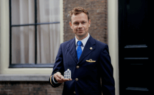 KLM crew member holding the Delft Blue House.