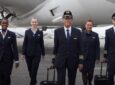 EL AL crew members stand in front of an aircraft in new uniforms.