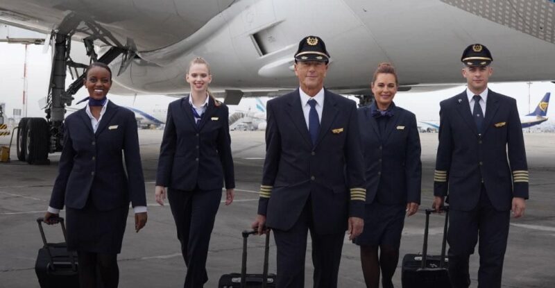 EL AL crew members stand in front of an aircraft in new uniforms.