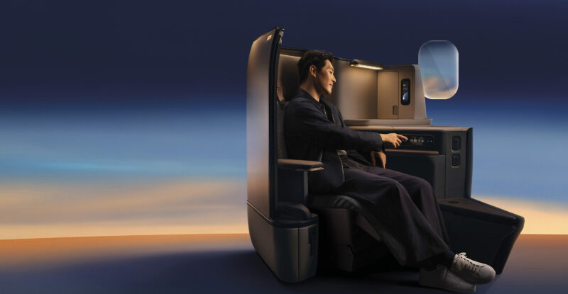 Passenger sits in Cathay's Aria suite with calm lighting all around