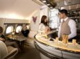Emirates crew members serve customers in the airline's bar aboard the A380. ACS UK supports the airline with social spaces.