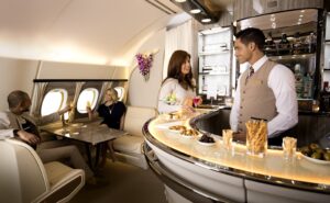 Emirates crew members serve customers in the airline's bar aboard the A380. ACS UK supports the airline with social spaces.