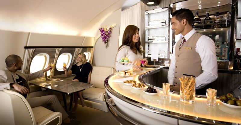 Emirates crew members serve customers in the airline's bar aboard the A380. ACS UK supports the airline with social spaces.