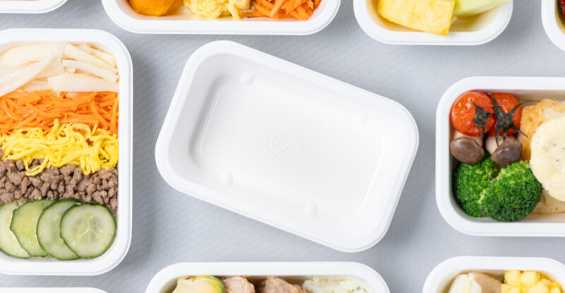 Various Korean Air meals on display in their new plant-based containers.