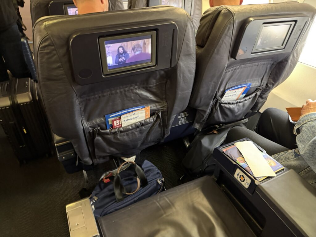 A close up of the seats in the United Airlines cabin shows an older in-seat IFE system