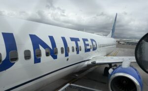 Looking down the side of the United Airlines aircraft while it is parked at the gate for boarding.