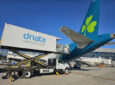 A dnata truck is loading supplies onto an Aer Lingus aircraft.