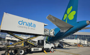A dnata truck is loading supplies onto an Aer Lingus aircraft.