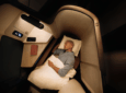 A passenger is asleep in the lie-flat seat onboard an aircraft.