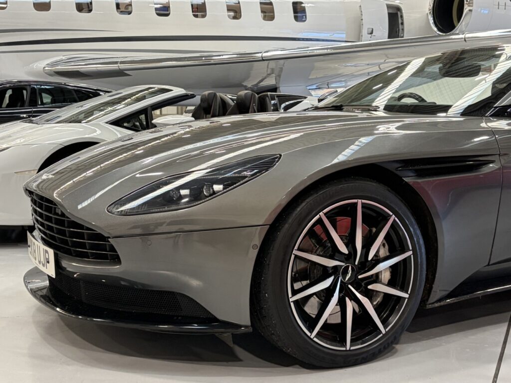 An Aston Martin sits in the hangar next to the Global 8000.