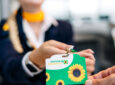 A Lufthansa crew member is handing the sunflower lanyard to a passenger