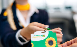 A Lufthansa crew member is handing the sunflower lanyard to a passenger