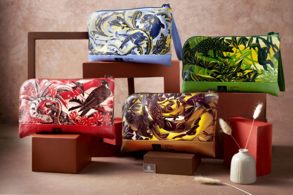 Four Emirates amenity kits are on display. A blue, red, green and yellow version.