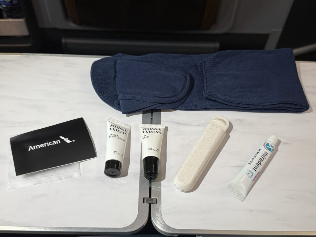 The amenity kit contents include skincare products and socks.