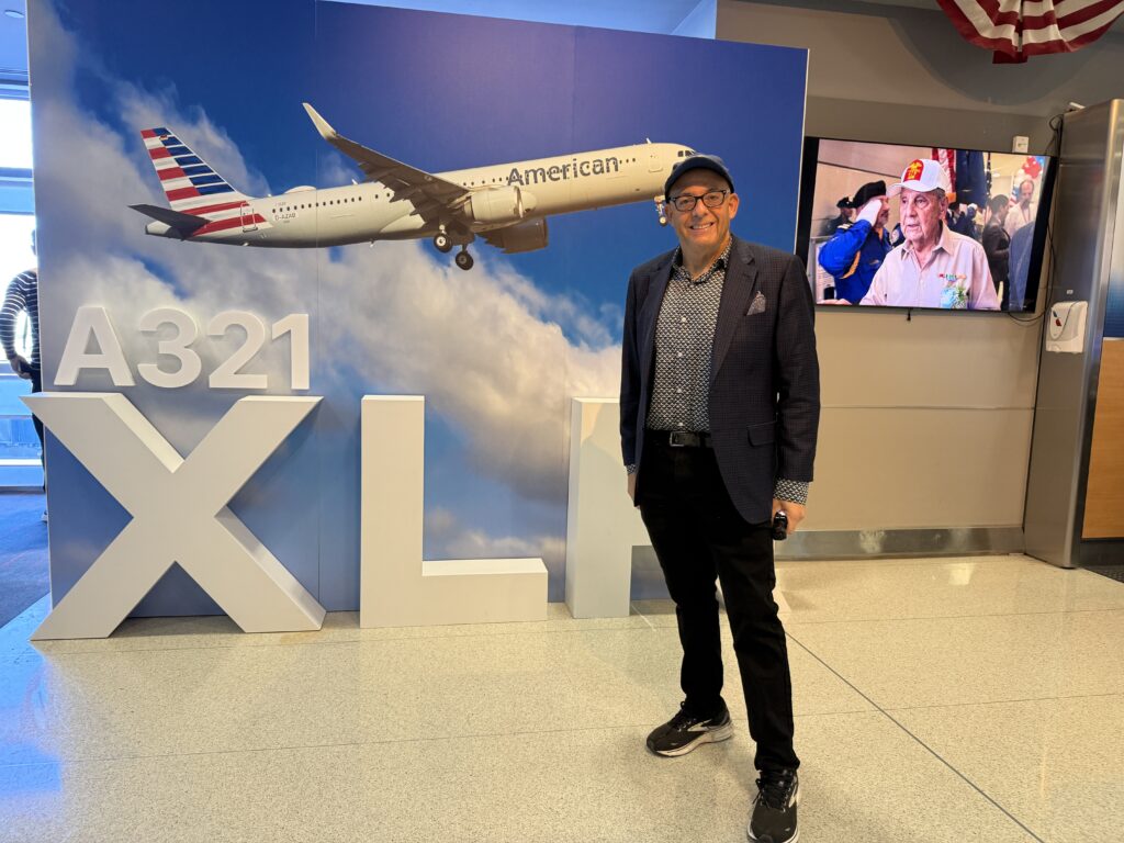 Author Chris Sloan is standing by A321XLR signage at JFK.