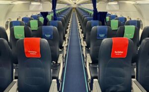 The Iberojet A320 cabin. The seats are blue with alternating red, green and blue headrest covers.
