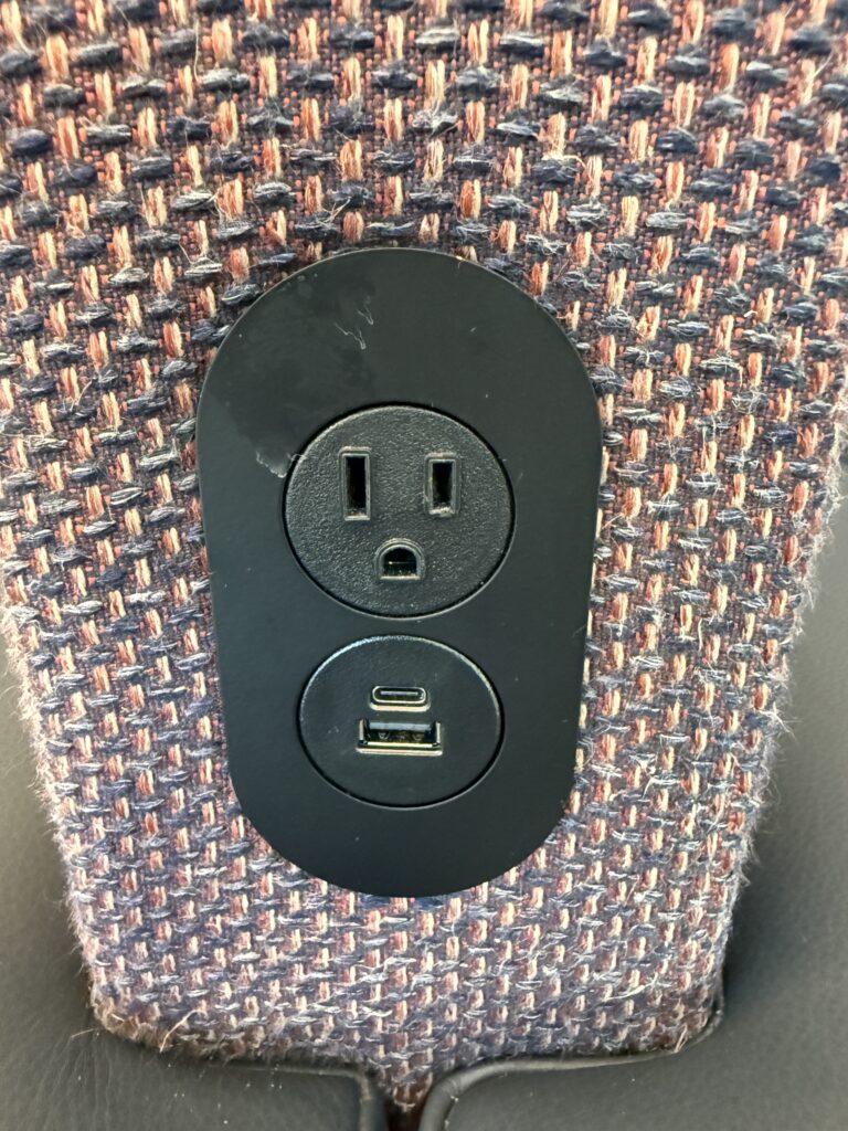 A close up of the power outlets in a seat.