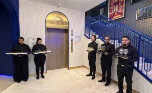 BlueHouse lounge staffers welcome guests with beverages at the entrance