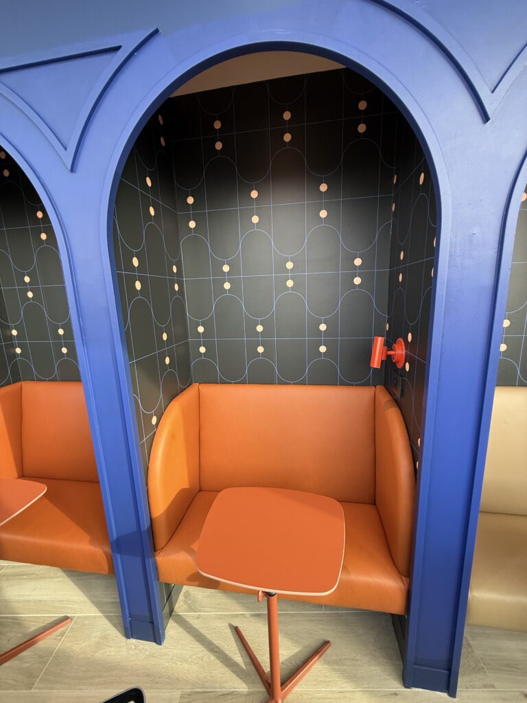 A seat tucked into a private space with a table in front of it.