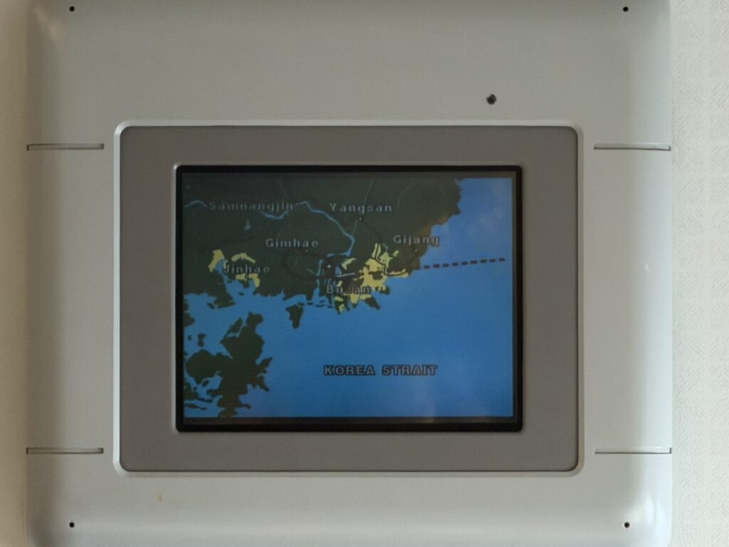 Overhead video monitors showing a moving map of the flight.