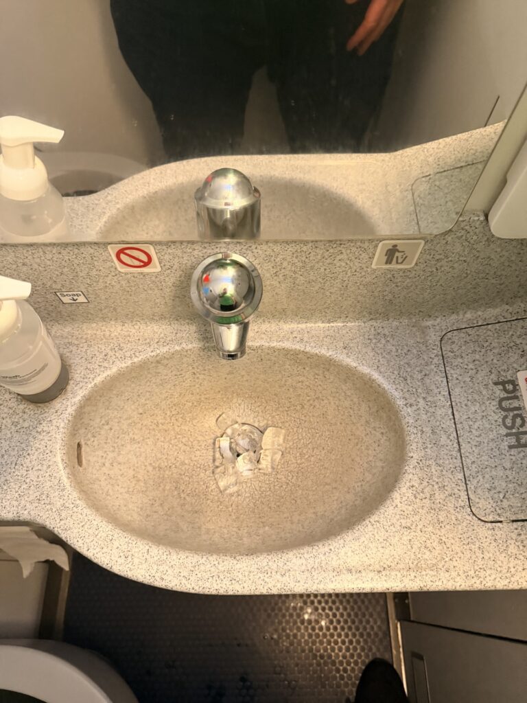 The aircraft lavatory sink is pictured here with a handful of ice cubes in it. 