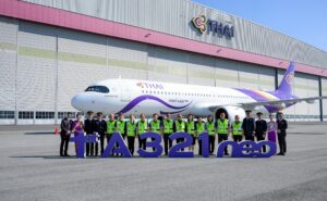 A large group of Thai Airways employees standing in front of the new A321neo.