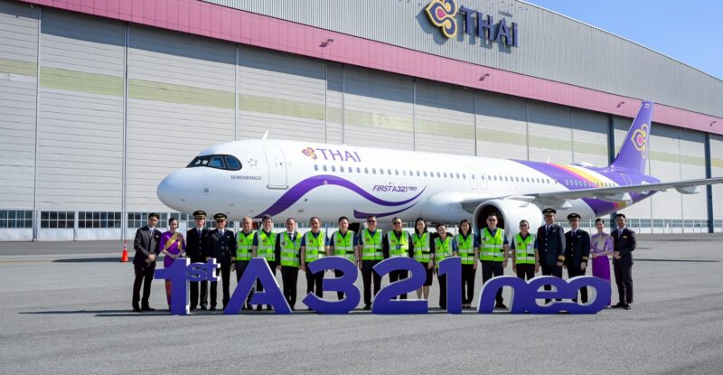 A large group of Thai Airways employees standing in front of the new A321neo.
