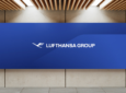 A dark blue back drop with the Lufthansa Group logo is displayed on a wall.