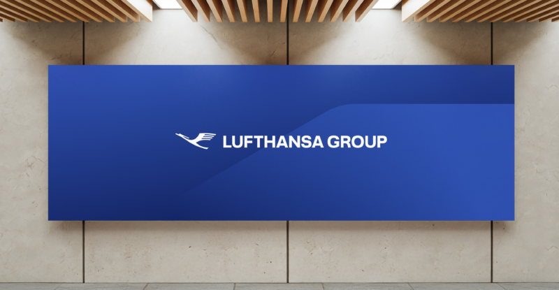 A dark blue back drop with the Lufthansa Group logo is displayed on a wall.