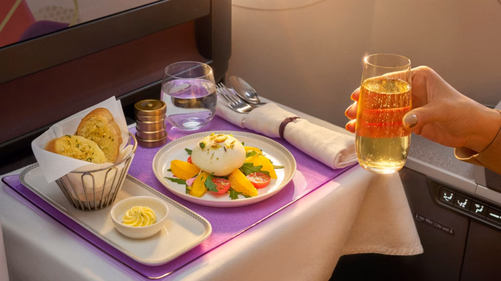 A glass of champagne is paired with Air India's Citrus Burrata.