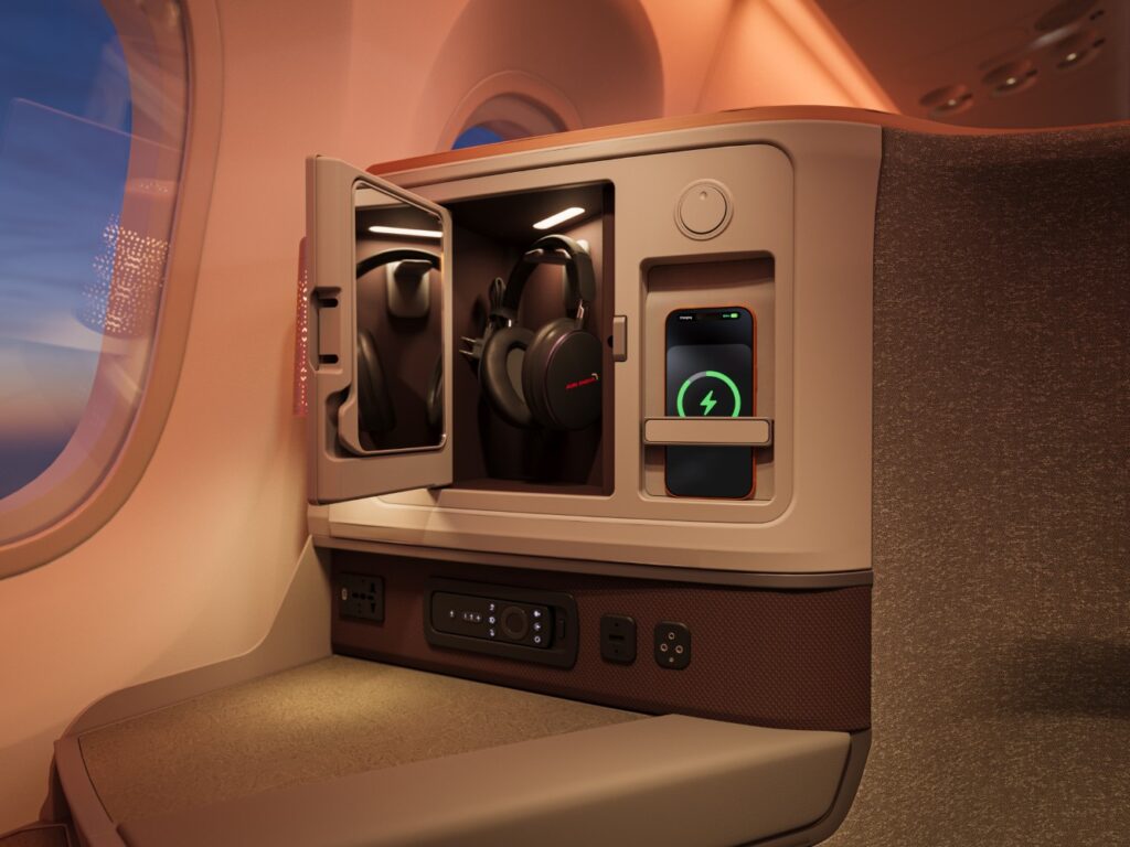 A cubby with headsets hanging in it. A device is being charged by the wireless charger beside it.