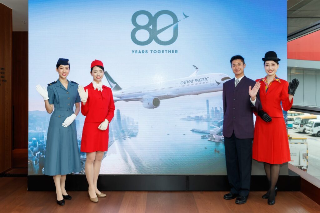 Cathay crew members pose in various crew uniforms of the past at the anniversary.