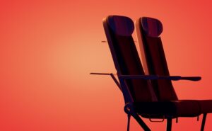 Two Expliseat aircraft seats on an orange-red background. The seats are being positioned as ideal for North American regionals.