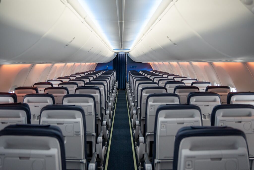 LOT Polish Airlines Boeing 737 new cabin with rows of slimline seats and calm mood lighting.
