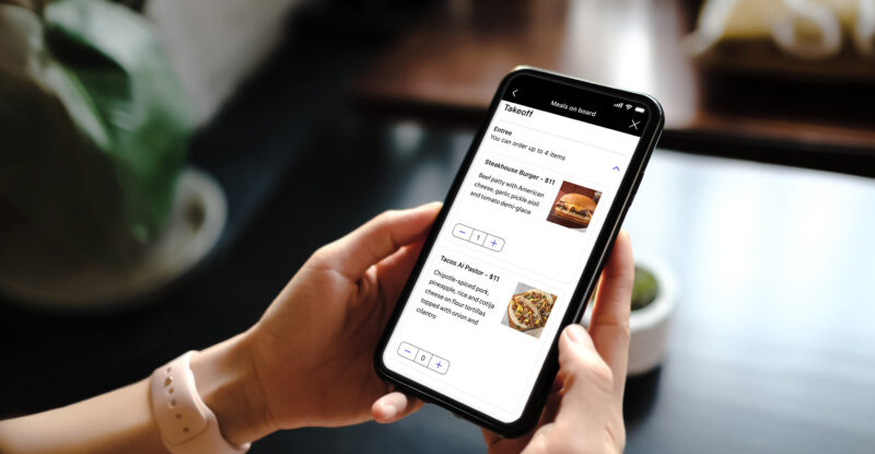 A passenger is looking at the United Pre Pay Bistro app on their mobile device.
