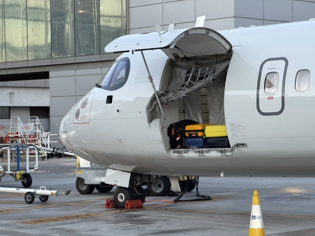 Luggage door is open on the ATR, with suitcases inside.