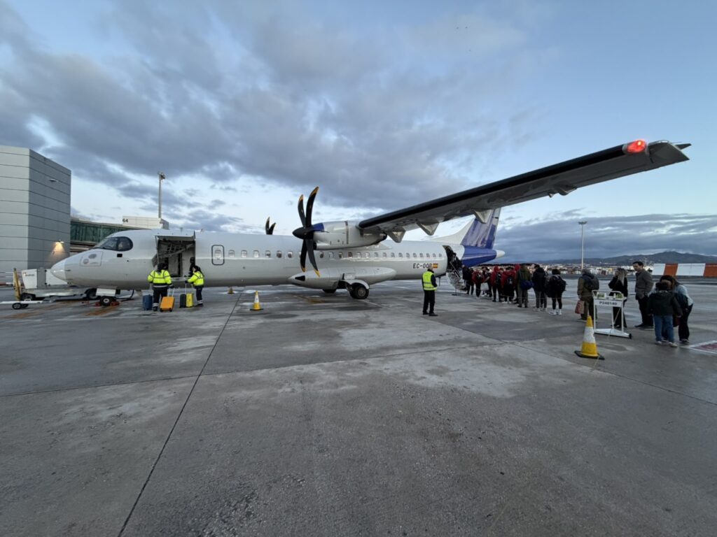 ATR 72 parked and ready to board. Passengers line up.