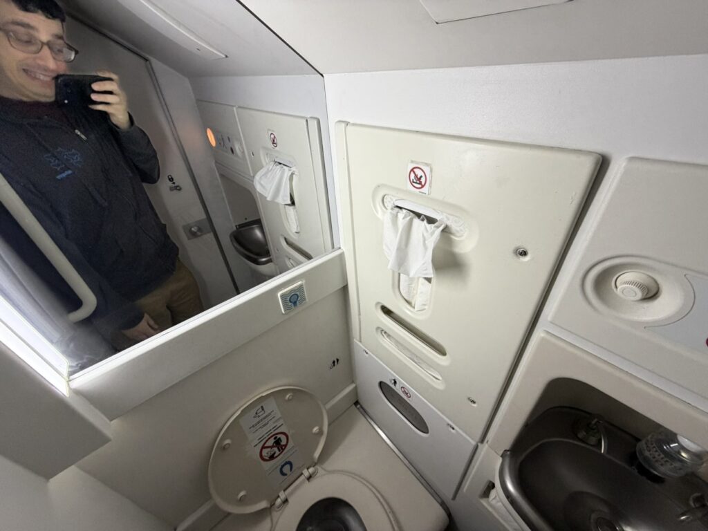 The author smiles in the mirror as he snaps a pic in the lav