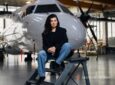 Anastasija Visnakova of Deutsche Aircraft is sitting in front of an aircraft.