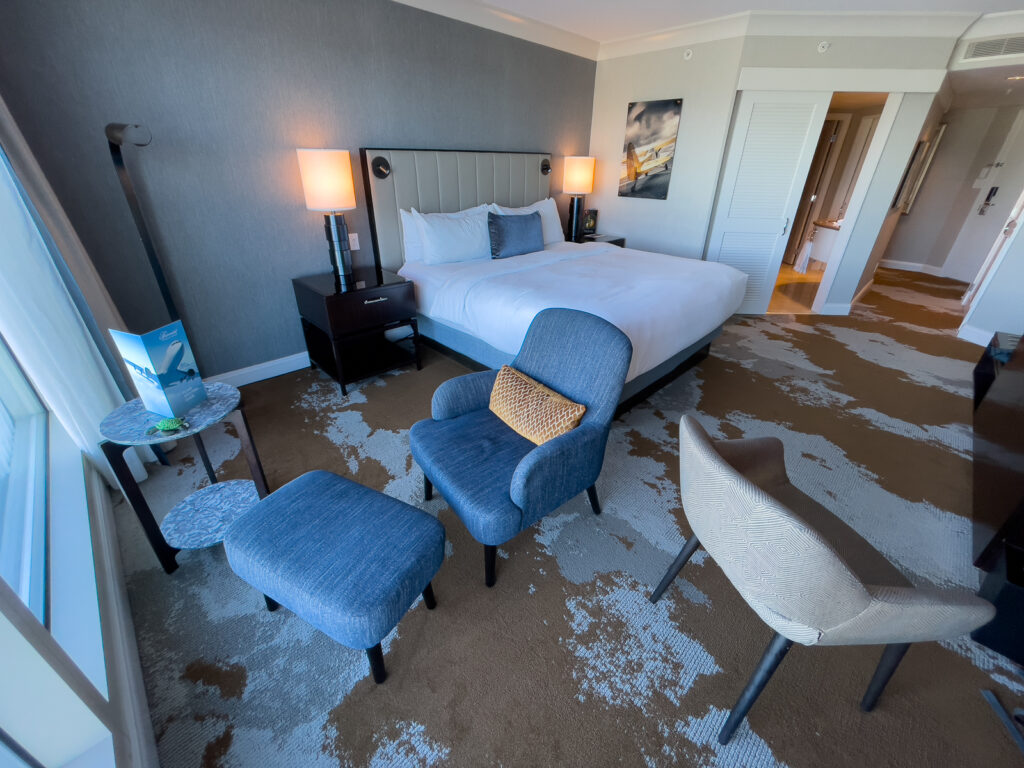 A view of the inside of the hotel shows a bed and various places to sit in a nice amount of space.