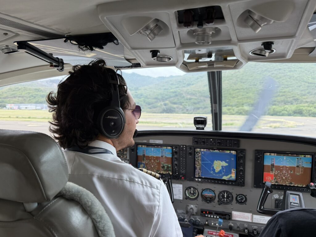 A pilot is in the cockpit of the Cessna Grand Caravan.