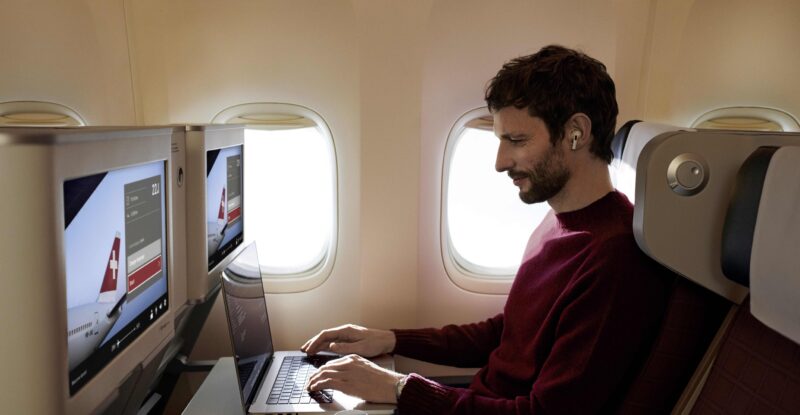 Passenger on board SWISS widebody enjoys Starlink inflight Wi-Fi on his laptop. SWISS is a member of the Lufthansa Group