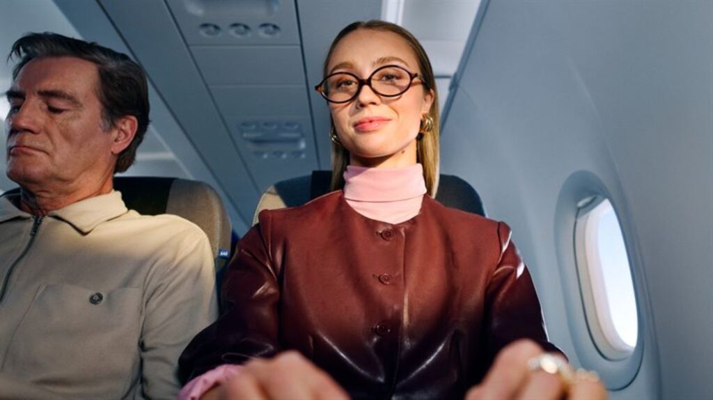 A female passenger is using her laptop in flight with SAS wifi powered by Starlink.