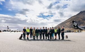 Pictured in the image from left to right: Alessandra Paladino and her dog named Darcie - EDD Officer (Dog Handler) Hanna Hyde - Aircraft Service Agent - Baggage and Baggage loading Jess Klitscher - Air Traffic Controller Tegan Stallard - AES Acting Up Crew Chief (Fire) Scarlett Meikle - Air NZ Customer Service Bridget Martin - Operations Manager - Queenstown Airport (NZ Aviation Security Service / AVSEC) Sara Mulvey - Air NZ First Officer (Pilot) Shivani Prasad - Air NZ Cabin Crew Jana Fort - Queenstown Airport Duty Manager Thyra Blaom - Air NZ Captain (Pilot) Sina Muavae - Air NZ Cabin Crew Kristal Tall - Aircraft Turn Coordinator Priscila Machado Cordeiro - Air NZ Customer Service Rosie Ulrisch & dog named Baz - EDD Officer (Dog Handler)